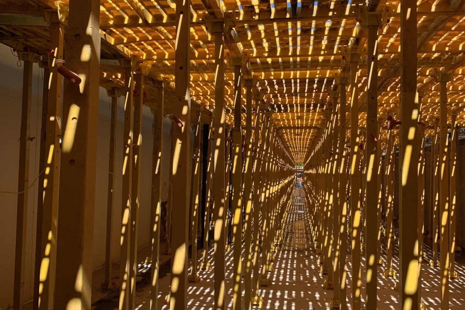 Beneath a Trad Deck platform, rows of yellow leg units with light through the panels