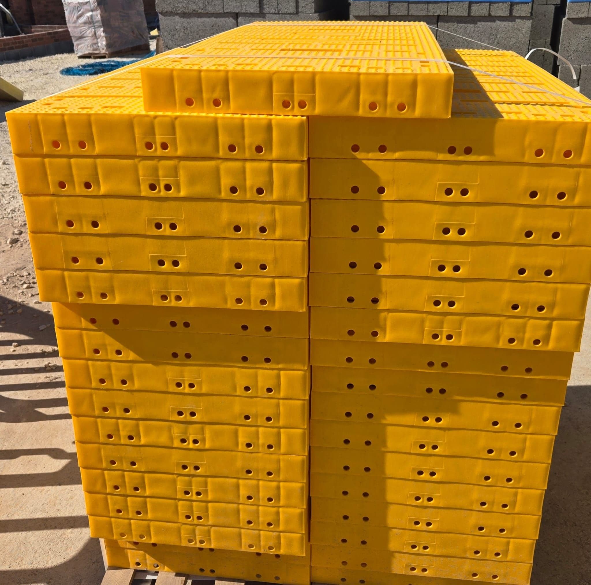 A stack of yellow Trad Deck panels on a pallet