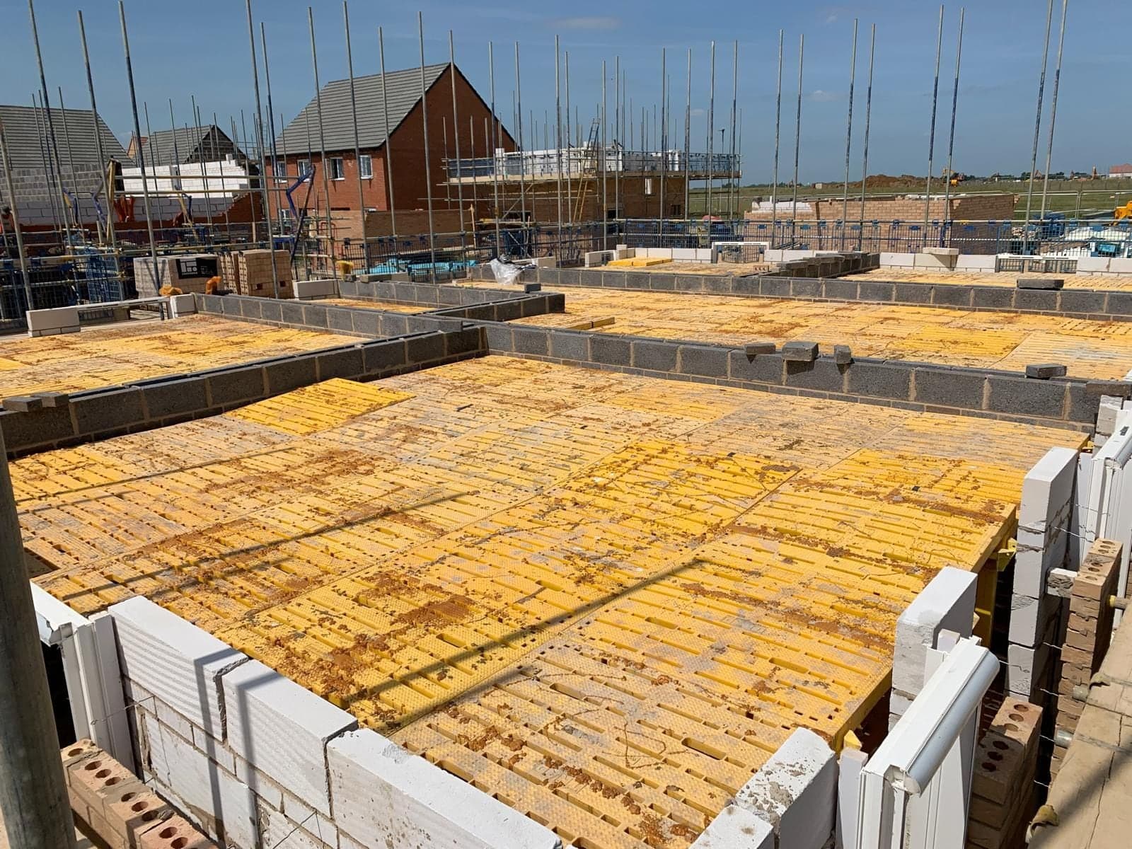 Trad Deck installed across the first floors of new-build house plots, finished homes beyond
